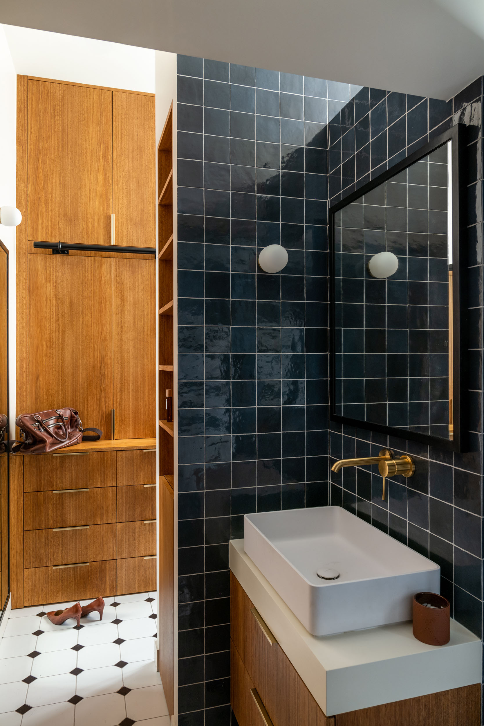 Salle d'eau avec carrelage bleu nuit et robinetterie laiton