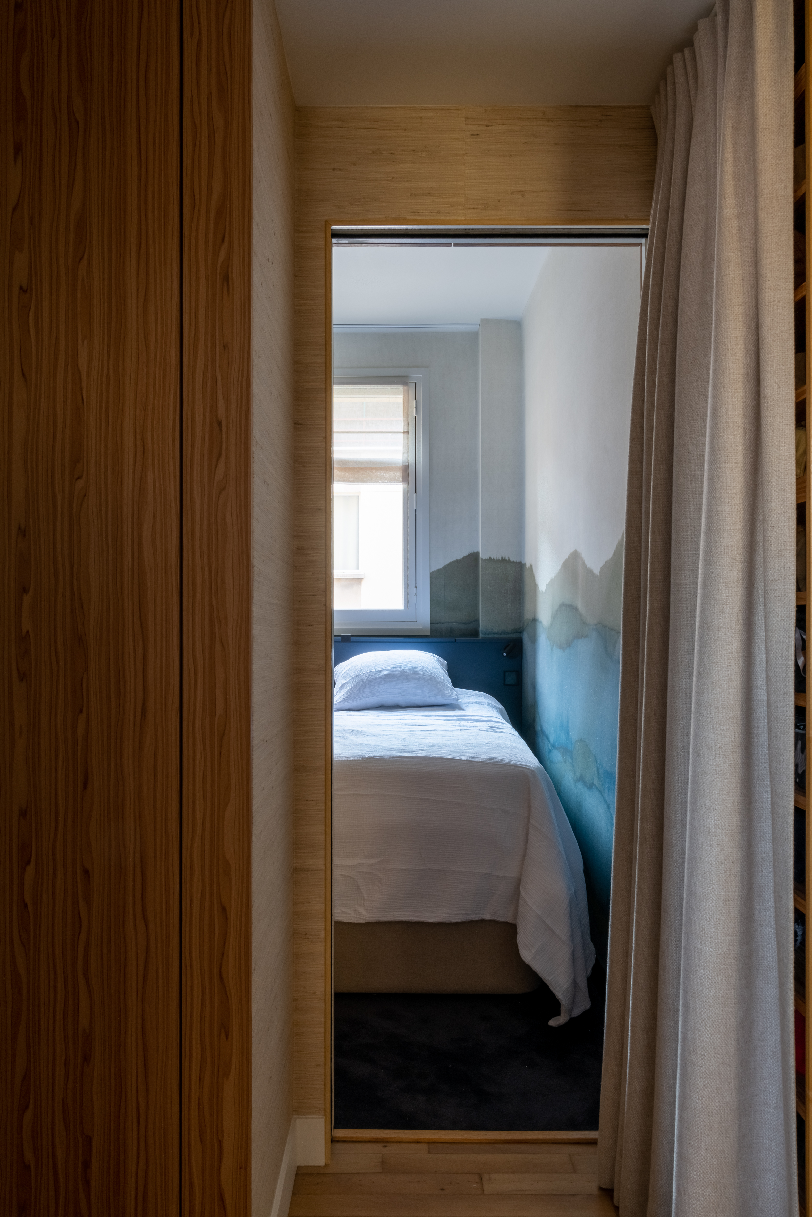 Chambre aper&ccedil;ue depuis un dressing avec rideau et bois